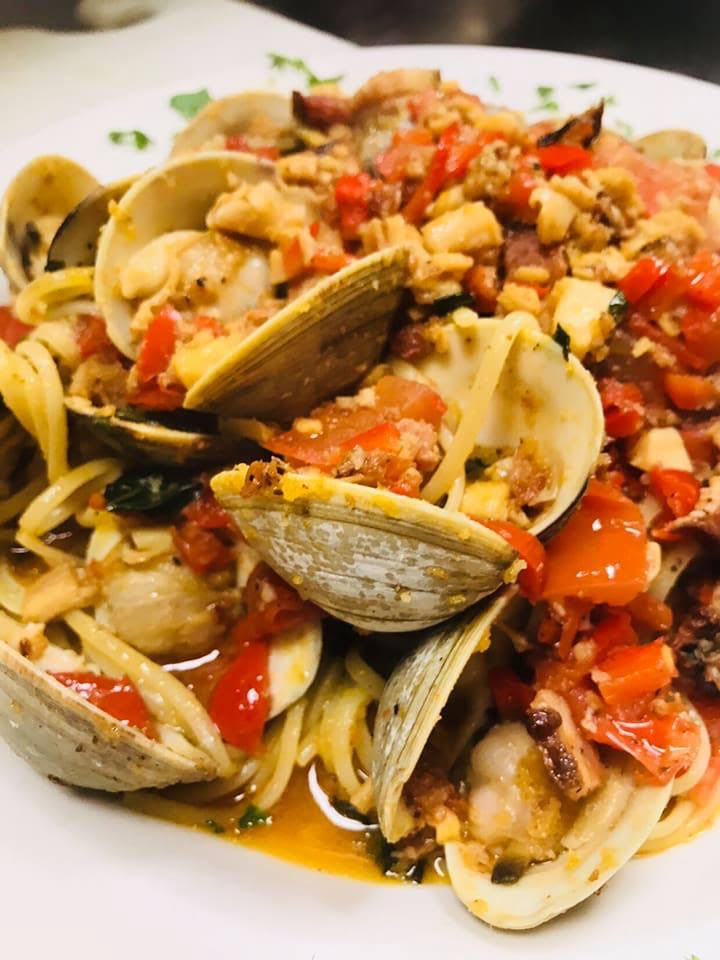A plate of pasta with clams and tomatoes.